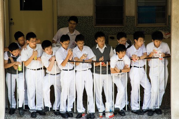 School boys watch a basketball game