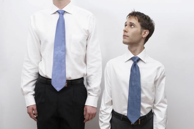 Short business man standing next to tall man