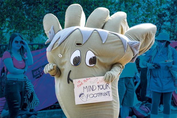 Climate protester dressed as a giant carbon footprint