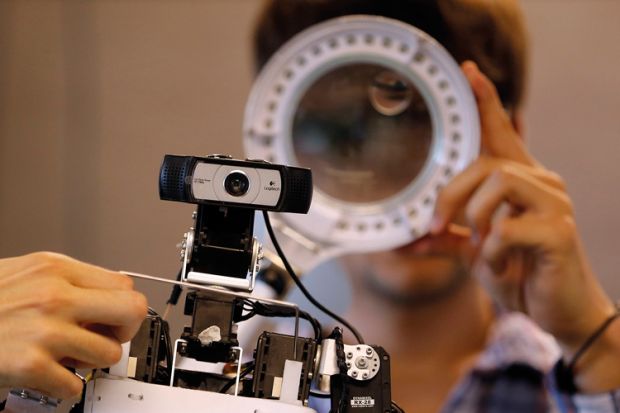 Members of the Rhoban project's team check functions of a humanoid robot at the LaBRI workshop in Talence, southwestern France, July 7, 2014. The humanoid robot, one of four, which is developed by researchers and students from the University of Bordeaux, 