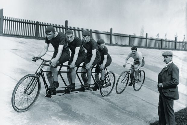 A four-man cycling tandem team in training with the 'chase and pacemaker' whilst being timed on the stopwatch. A four-man cycling tandem team in training with the 'chase and pacemaker' whilst being timed on the stopwatch.