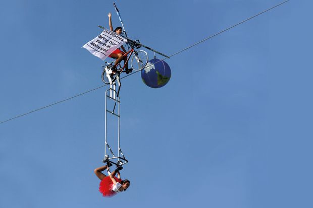 Tightrope artists balance a globe Tightrope artists balance a globe