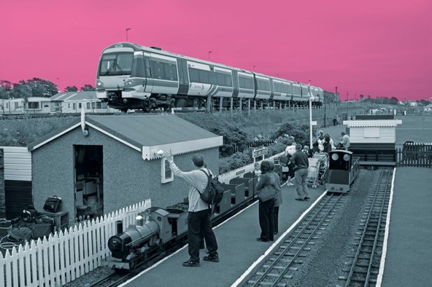 Miniature railway next to real train Miniature railway next to real train