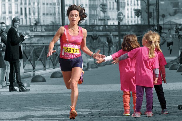A female runner giving children a high five as she runs past. A female runner giving children a high five as she runs past.
