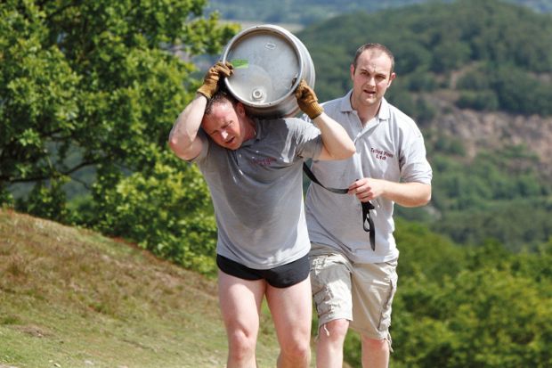 Tired man carrying beer barrel uphill Tired man carrying beer barrel uphill