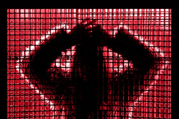 Silhouette of young woman behind window