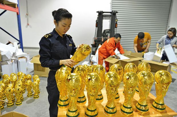 A woman standing over a box of football trophies A woman standing over a box of football trophies