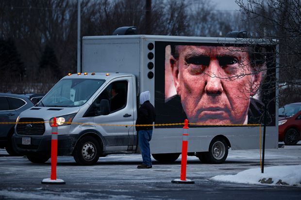 A digital billboard truck with a giant image of Donald Trump tries to park outside a campaign rally