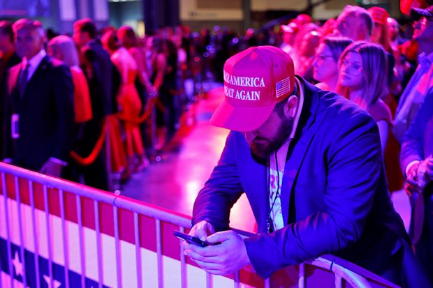 A supporter looks at his phone during an election night watch party for Republican presidential nominee, Donald Trump, at the Palm Beach Convention Center on 5 November 2024.