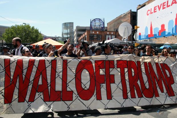 Cleveland, Ohio, USA - July 20, 2016: Participants in the 'Wall Off Trump' immigration march and rally demonstrate outside the Quicken Loans Arena, site of the Republican National Convention, on its third day. Cleveland, Ohio, USA - July 20, 2016: Participants in the 'Wall Off Trump' immigration march and rally demonstrate outside the Quicken Loans Arena, site of the Republican National Convention, on its third day.