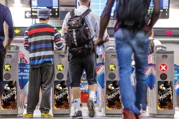 People passing through turnstiles People passing through turnstiles