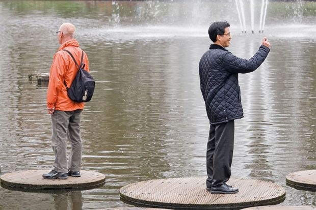 two men stand back to back