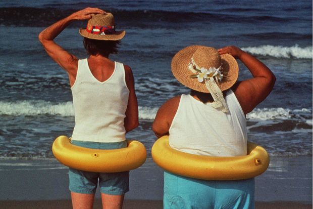Two people on the beach looking out to sea Two people on the beach looking out to sea