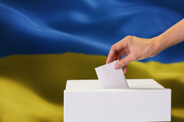 A ballot box in front of a Ukrainian flag A ballot box in front of a Ukrainian flag