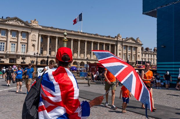 A spectator wrapped in a British Union flag shelters from the sun with an umbrella near the Paris 2024 Olympic Games Concorde stadium venue in Paris, France, 2024. To illustrate the return of the Erasmus+ programme. A spectator wrapped in a British Union flag shelters from the sun with an umbrella near the Paris 2024 Olympic Games Concorde stadium venue in Paris, France, 2024. To illustrate the return of the Erasmus+ programme.