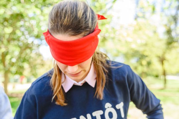 Valencia, Spain - April 7, 2019 Group of young people in an outdoor school playing cover their eyes with a red veil to find the partner, and thus develop social skills. Valencia, Spain - April 7, 2019 Group of young people in an outdoor school playing cover their eyes with a red veil to find the partner, and thus develop social skills.