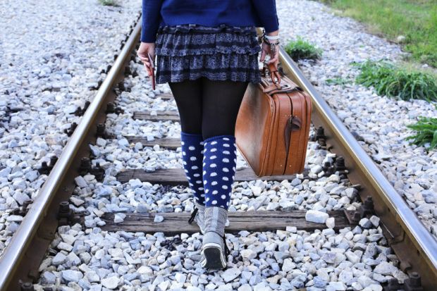 Woman walking alone on railway tracks