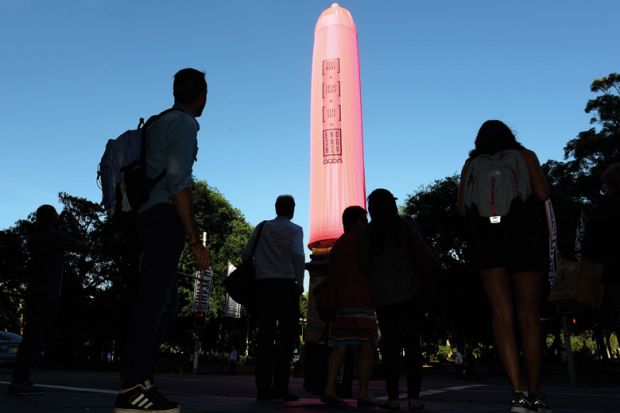 People look at a gaint condom over a heritage-listed obelisk at Hyde Park in Sydney People look at a gaint condom over a heritage-listed obelisk at Hyde Park in Sydney to illustrate Concern over HIV cases among Australia’s international students