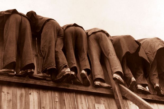 row of men bent over fence
