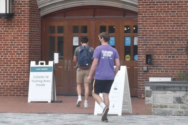 Students wearing face masks enter a makeshift COVID-19 testing area at Georgetown University 