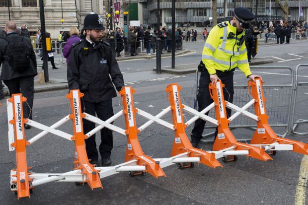 Met police officers drag barriers into place in London Met police officers drag barriers into place to illustrate opposition in Whitehall to Home Office plan for graduate visa limits