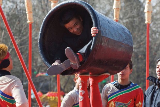 Person in a small container during a performance in China Beijing Person in a small container during a performance in China Beijing to illustrate Universities ‘in tricky position’ on Chinese student contracts