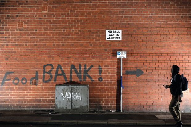 A sign painted on the side of a house directs people to a local food bank  to illustrate Halfon: ‘No way I’ll support raising fees’