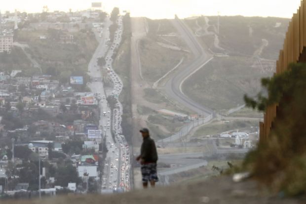 A man walks on the Mexican side of the U.S.-Mexico border barrier A man walks on the Mexican side of the U.S.-Mexico border barrier