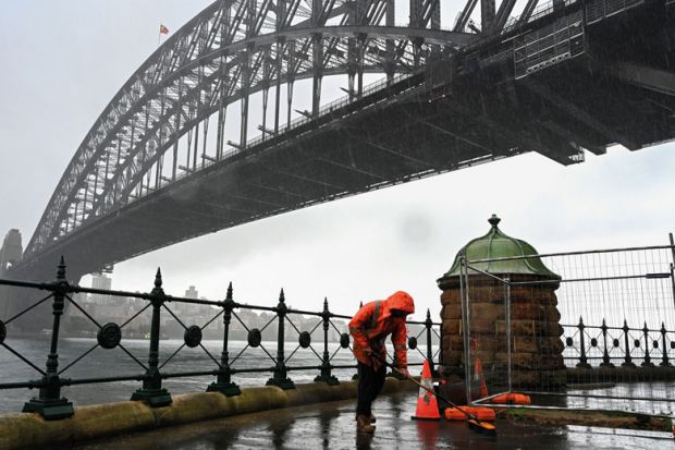 A construction worker sweeps away water while it rains next to the Harbour Bridge in Sydney A construction worker sweeps away water while it rains next to the Harbour Bridge in Sydney to illustrate Shortened work rights ‘complicate’ skills drive