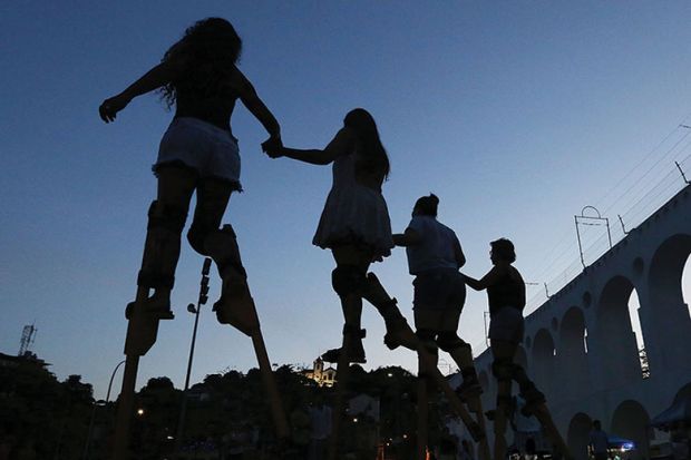 People practice walking on stilts during a stilt walking workshop as part of pre-Carnival festivities 
