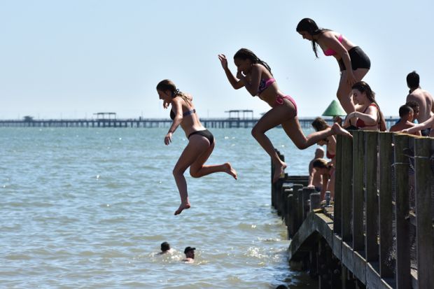 People jumping from a jetty into the sea in Southend-on-Sea, England People jumping from a jetty into the sea in Southend-on-Sea, England illustrate Value of domestic students almost halves at some UK universities