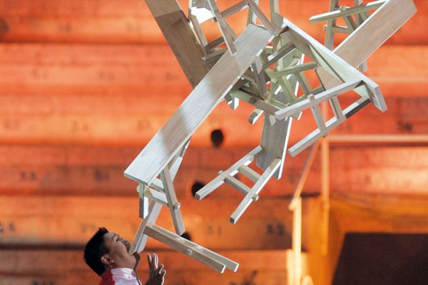 Chinese performer Guozhi Guo balances a stack of wooden trestle tables on his chin Chinese performer Guozhi Guo balances a stack of wooden trestle tables on his chin Weekend courses seek to give Chinese graduates employment edge