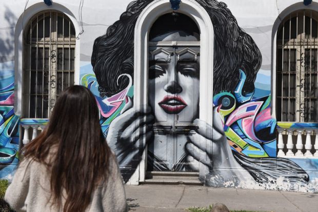 A woman walks past street art in Bellavista neighbourhood. A woman walks past street art in Bellavista neighbourhood.