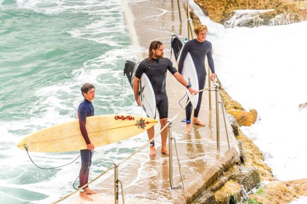  Surfers wait for the right time to enter the water from the Bronte Beach rock pool in Sydney to illustrate Take your time on new research sharing rules, Canberra is urged