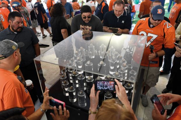 Football fans take a peek at Super Bowl rings in a glass display case Football fans take a peek at Super Bowl rings in a glass display case to illustrate they are looking at  a 'small piece of excellence' which resembles the university as the university teaches in a research base approach producing high qualit