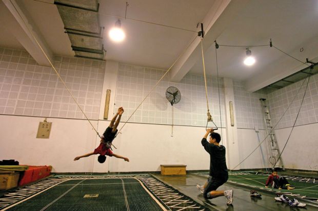 Person practices on a trampoline under the instruction of a coach to illustrate Probation period for PhD supervisors ‘could prevent exploitation’