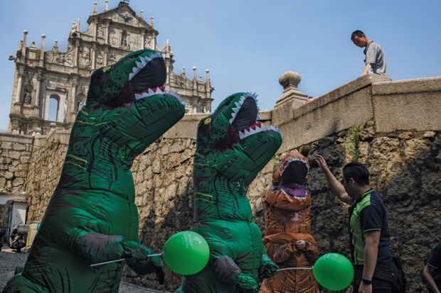 A man interacts with workers dressed in dinosaur costumes at the Ruins of St. Paul's Cathedral in Macau, China A man interacts with workers dressed in dinosaur costumes at the Ruins of St. Paul's Cathedral in Macau, China to illustrate University leaders ‘need to be better prepared for tough times’