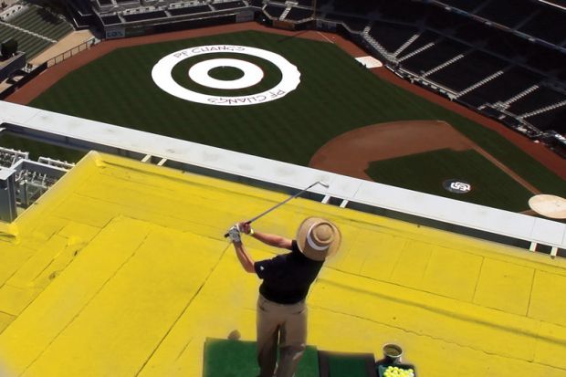 Player hits golf ball off a roof attempting to land the ball on a balls-eye planted in a field as a metaphor for Now is the time to take action on the UK’s R&D spending target
