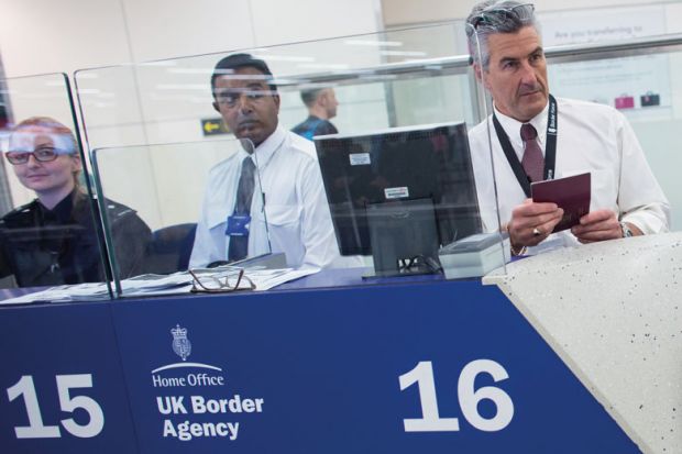 Border Force check the passports of passengers arriving at Gatwick Airport to illustrate Immigration check refusenik stripped of Keele fellowship