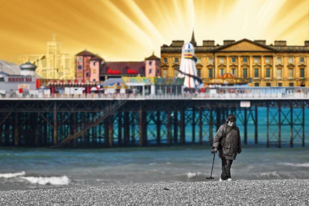 A metal detectorist searching on the shingle beach near Brighton Pier in East Sussex.