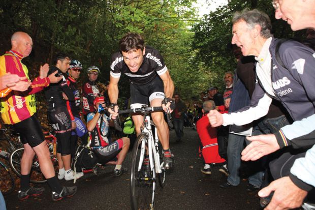 People cheering on man riding a bike as a metaphor for Incentivise staff to take part in innovation, universities told