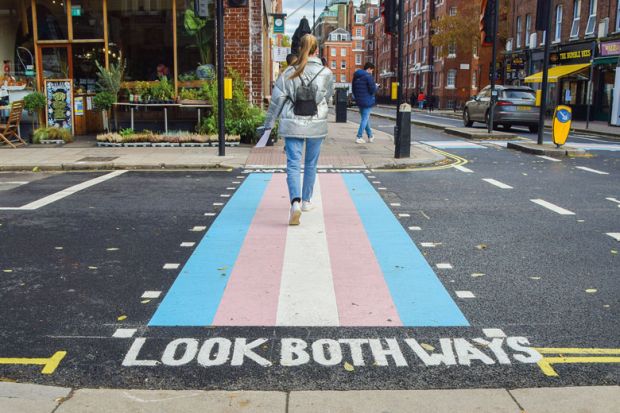 A woman walks along a pedestrian crossing with trans flag colours in Bloomsbury. A woman walks along a pedestrian crossing with trans flag colours in Bloomsbury. to illustrate Trans rights debate ‘is distracting union’