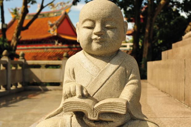 Statue of a Buddha reading at Kong Meng San Phor Kark See Temple in Singapore to illustrate What lessons can Singapore teach about lifelong learning