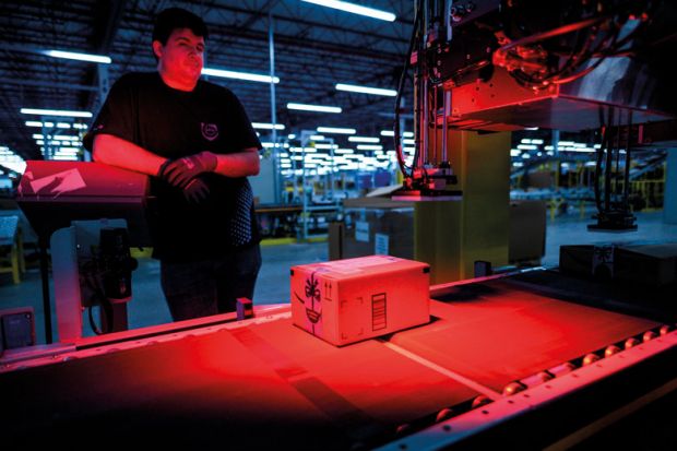 A man monitors the addressing process of a parcel inside an Amazon warehouse to illustrate Academics urge funding review after Toronto returns Amazon cash