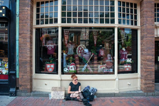 Young homeless girl sitting outside the Harvard University T-shirts books and souvenirs store in the city center Massachusetts Avenue, Cambridge, Massachusetts, USA Young homeless girl sitting outside the Harvard University T-shirts books and souvenirs store in the city center Massachusetts Avenue, Cambridge, Massachusetts, USA to illustrate edX architects tackle online access afresh with Axim