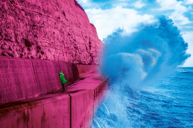 Lady watches waves crashing during stormy weather on Brighton  Under cliff walk to illustrate Don’t tell me I’ll get a permanent job eventually. I probably won’t