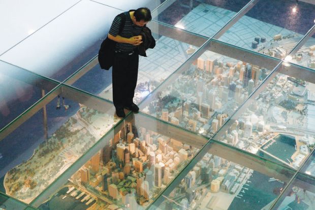 Person looks at a model of Sydney's central business district in central Sydney under a glass floor Person looks at a model of Sydney's central business district in central Sydney under a glass floor as a metaphor for China moves to halt universities’ eastern branch campus rush