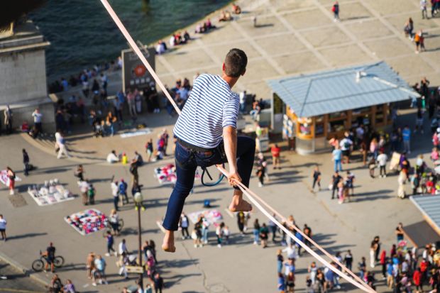 Tightrope walker Nathan Paulin traverses a slackline between the Eiffel Tower and the Trocadero Square to illustrate French universities avoid worst in election but face uncertainty