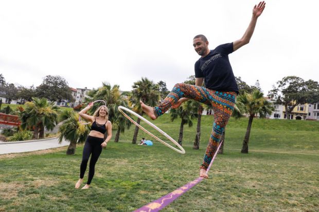 Person holding a hula hoop on a  tightrope practicing his skills to illustrate Want to improve students’ grades? Teach them life coping skills