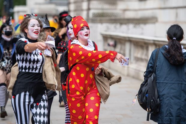 Protestors dressed as clowns hand out fake money in Westminster, London Protestors dressed as clowns hand out fake money in Westminster, London to illustrate Record £1.3 million severance pay for English sector leaders